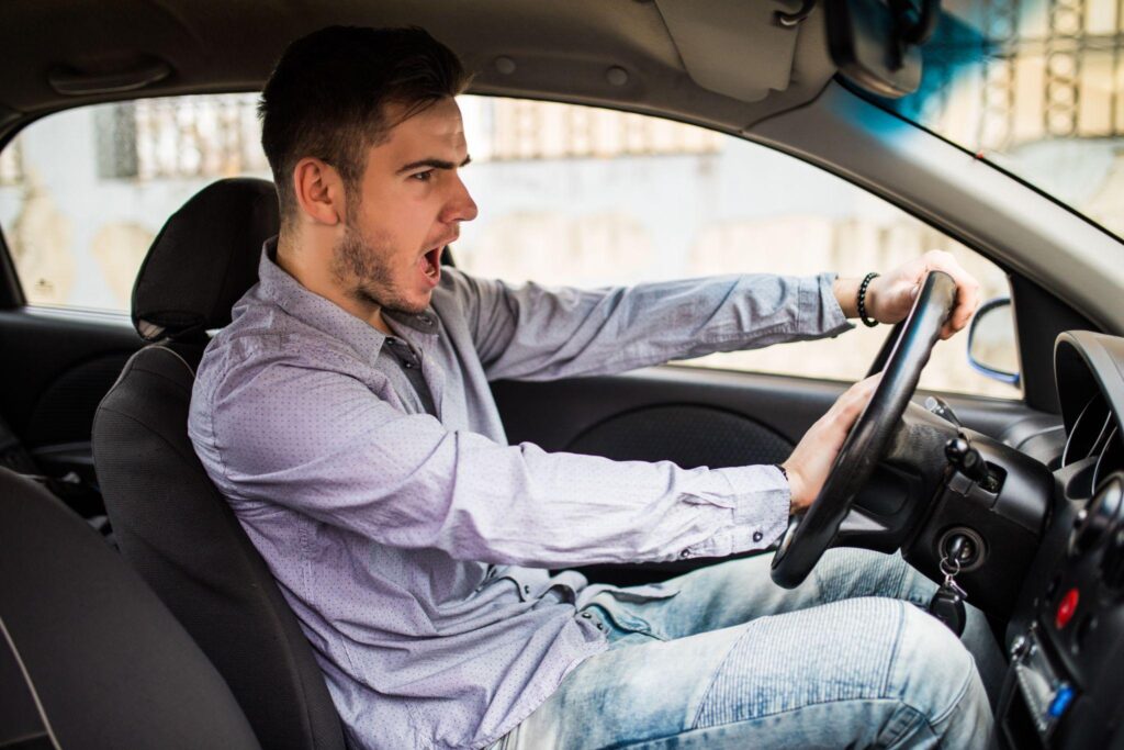 Driving instructor teaching student proper vehicle operation techniques